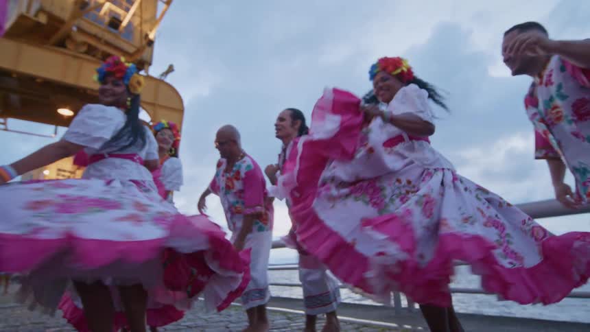 A group dance together and have fun by the water
