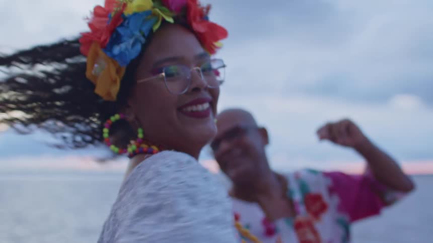 The woman smiles as she dances on the shore