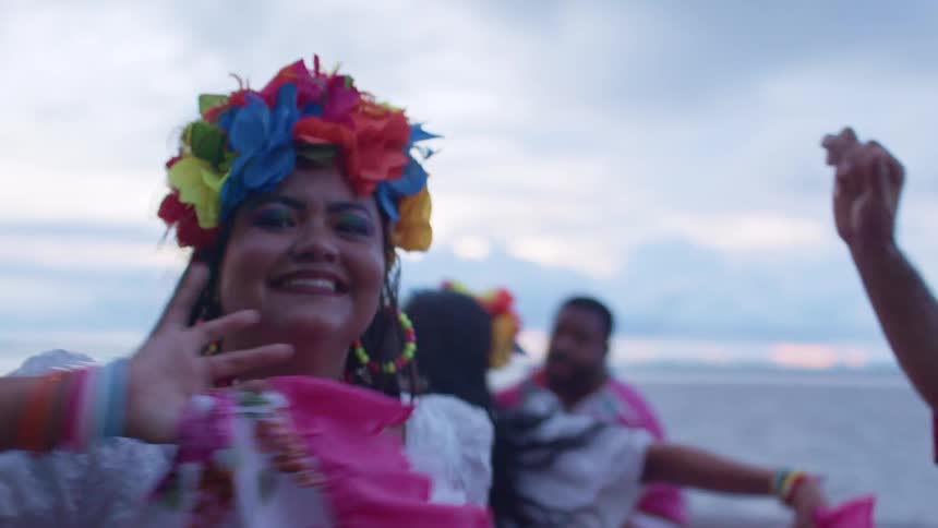 Smiling woman with colorful flowers on her head and beaded necklaces
