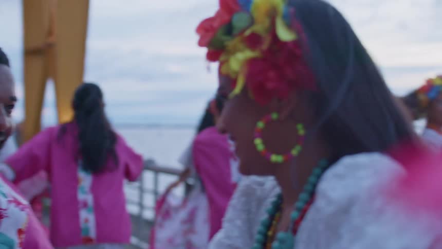 A group are dancing together on the boardwalk