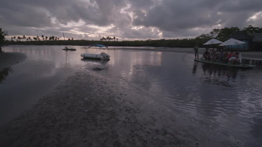 People ride on a row boat through the shallow water