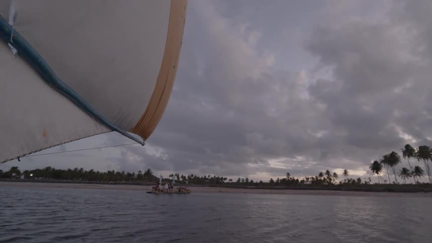 The sailboat moves by the shore