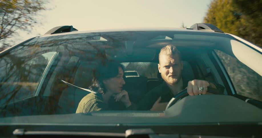 Wife comforts her upset husband while he drives on a road trip