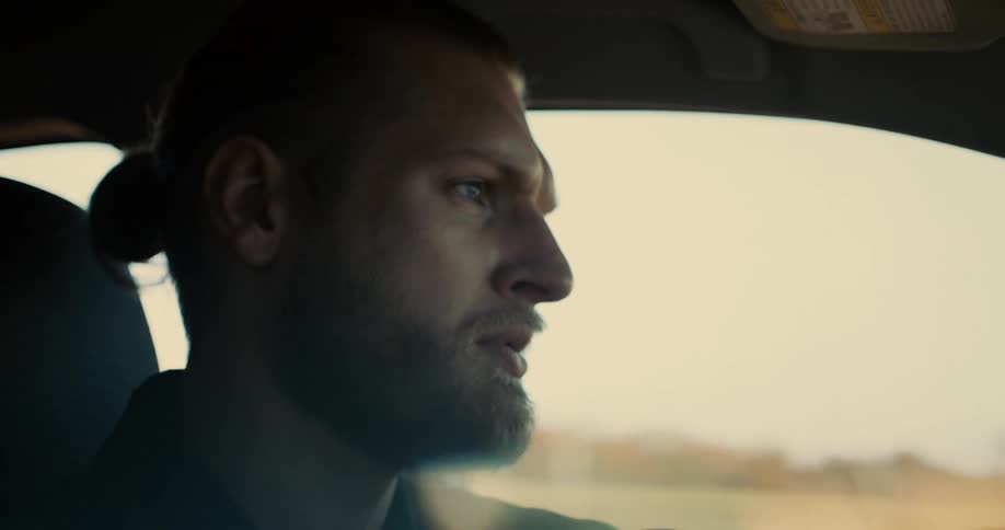 Bearded man driving a car with a focused look