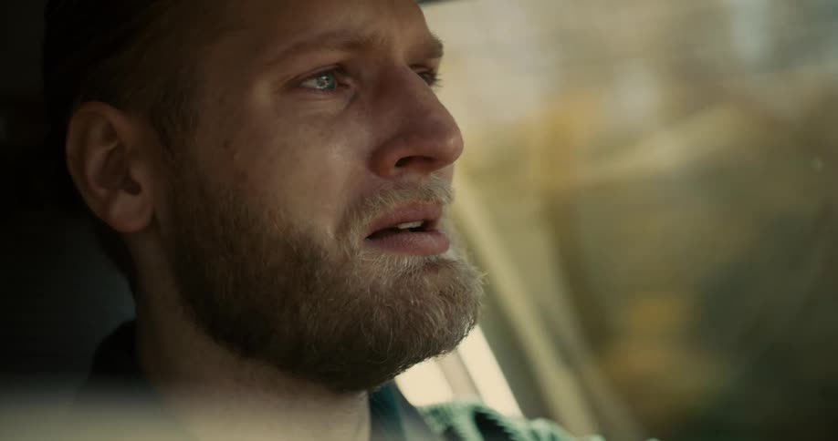 Bearded man driving while attentively watching the road