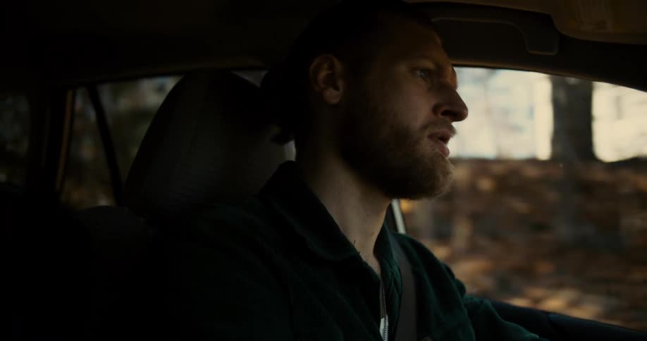 The man is driving on a sunny day