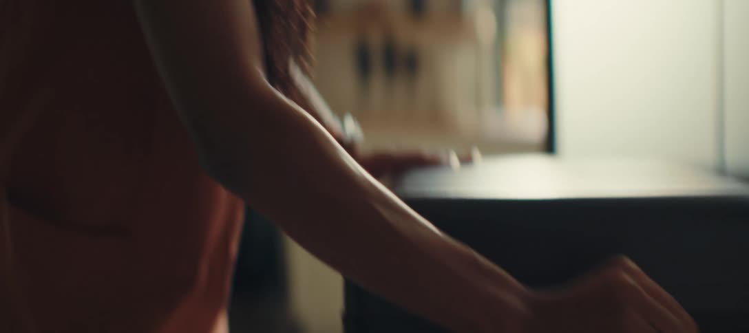 Woman opening a black suitcase on the bed