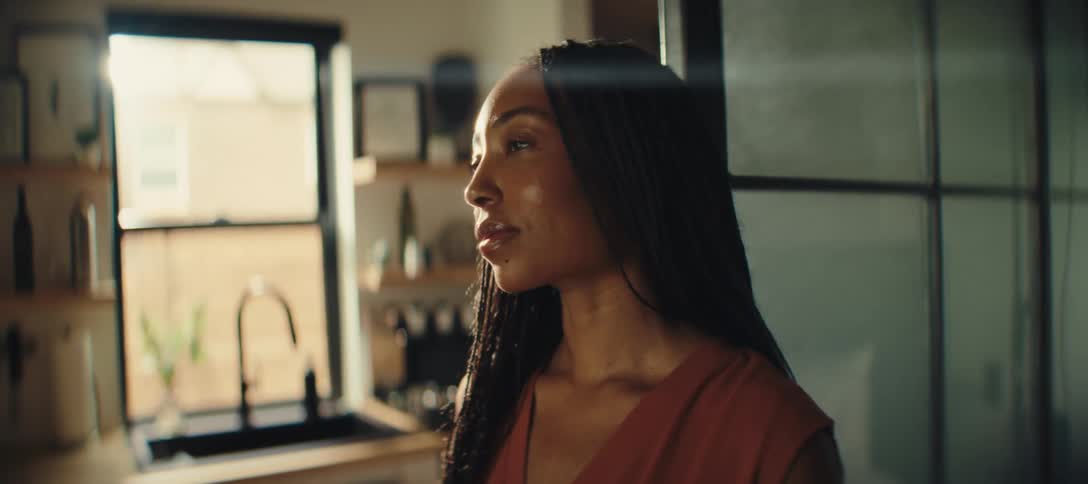 The woman is standing in her kitchen