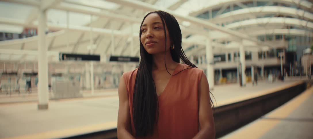 Woman standing with her luggage at the terminal as she looks at her watch