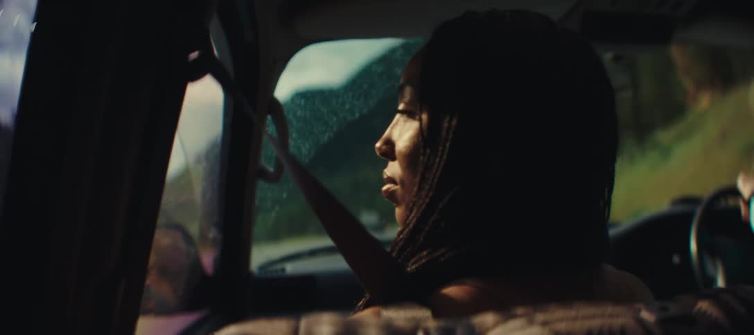 Woman sitting in the back seat of a car looks out the window during the ride
