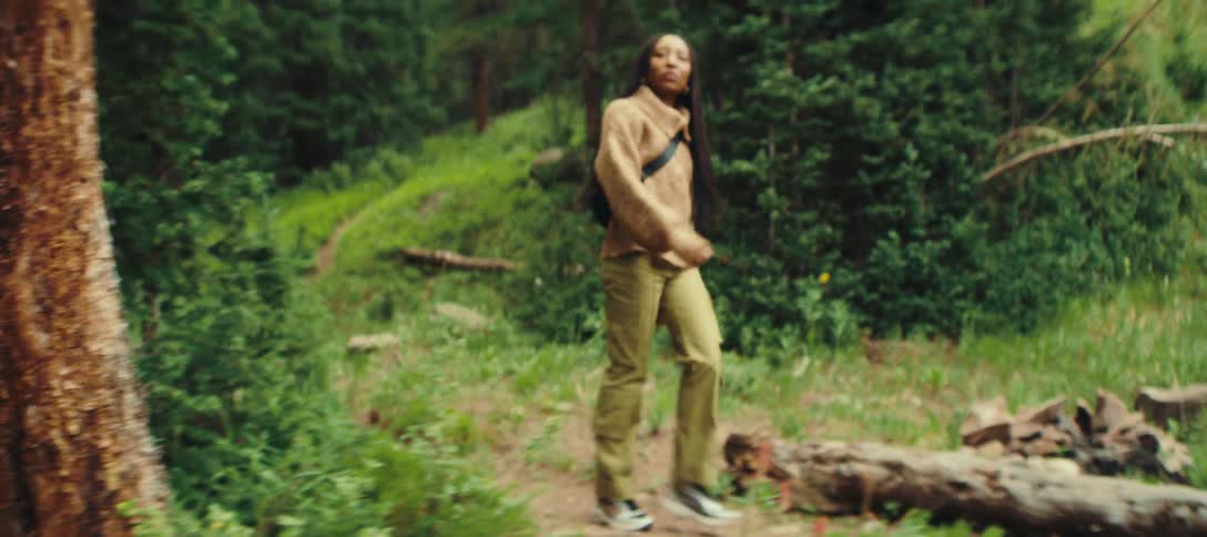 Woman walking along a trail in a dense forest