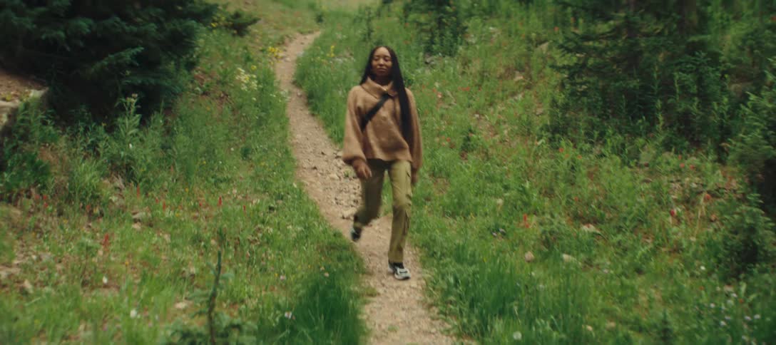 The woman hikes down the small trail
