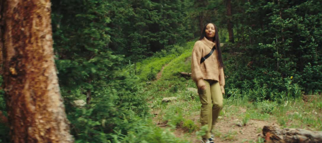 The woman hikes through the woods alone