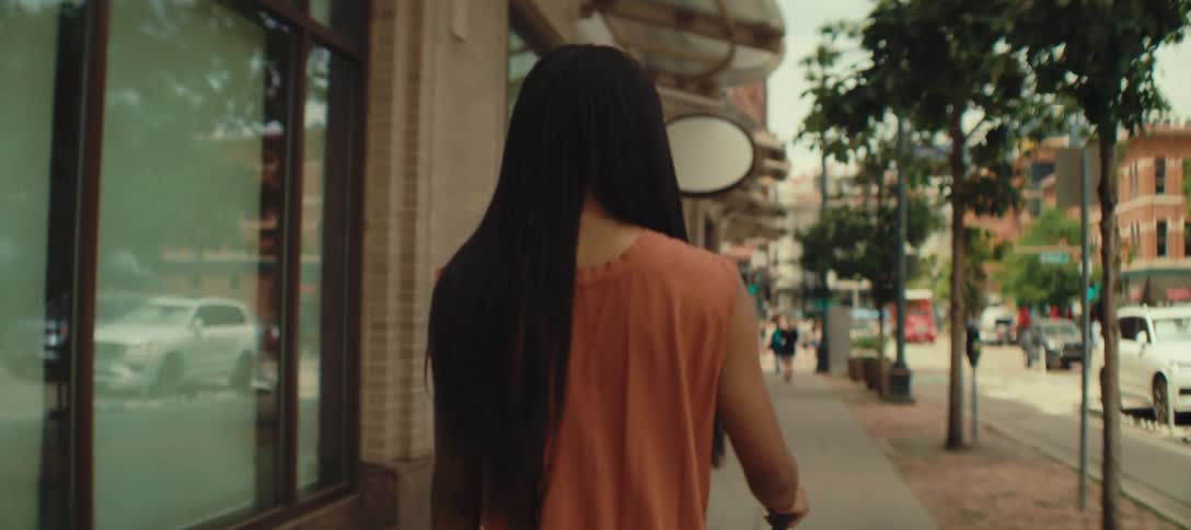 The woman rolls her luggage on the sidewalks