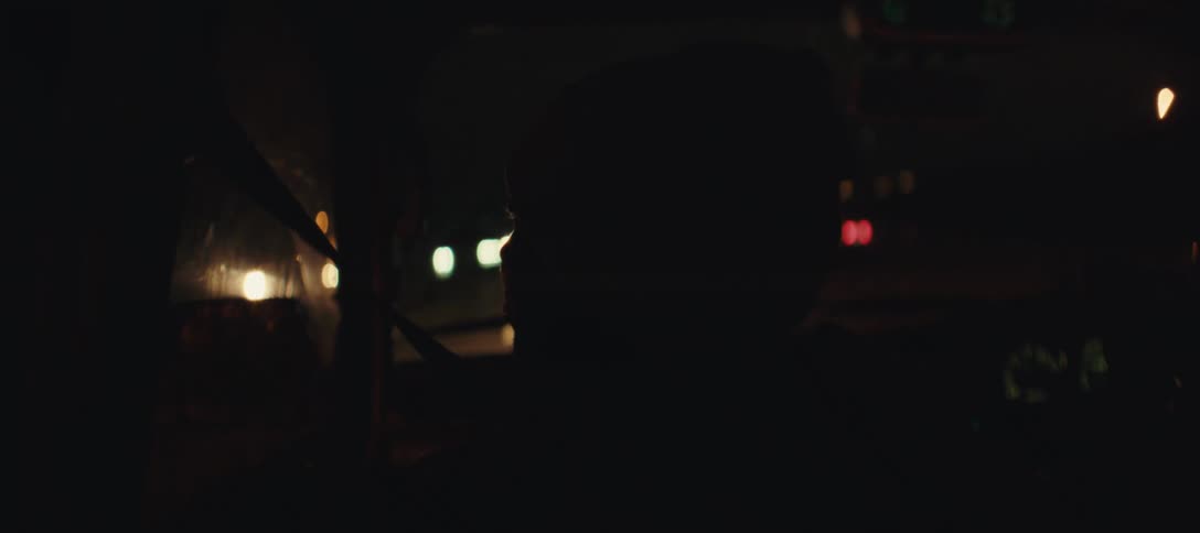 A person drives a car on a busy city road at night
