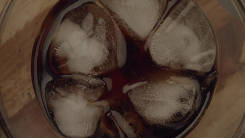 Closeup view of a glass filled with iced cola