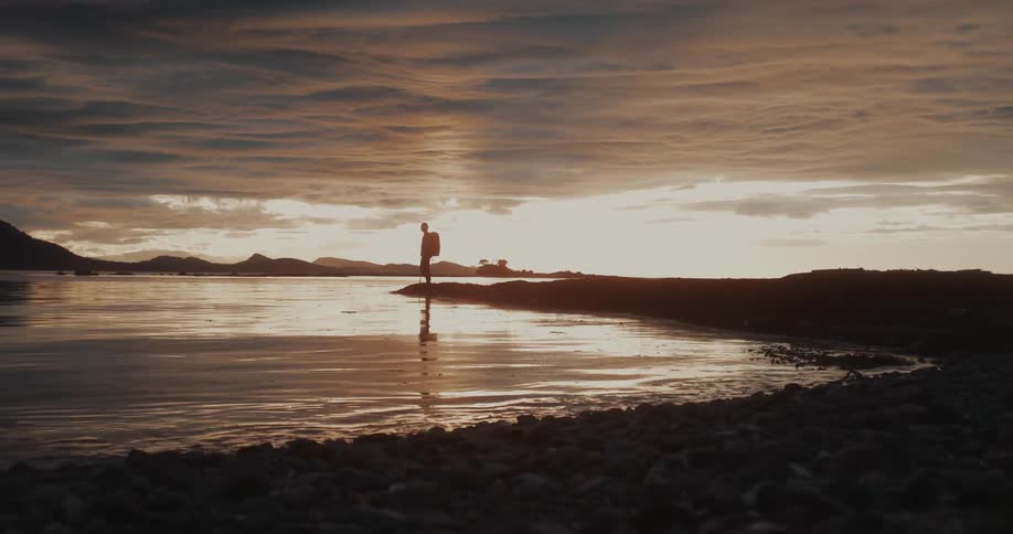 The backpacker stops by the lake at sunrise