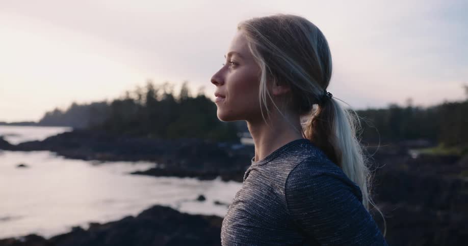 A girl stands by the coast