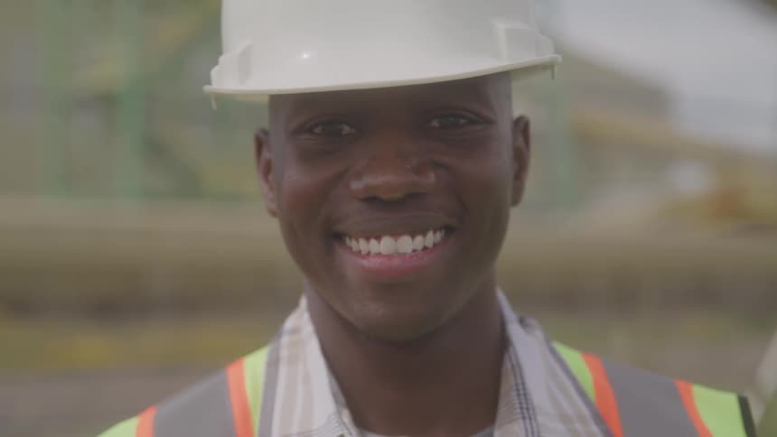 The worker is smiling on a sunny day