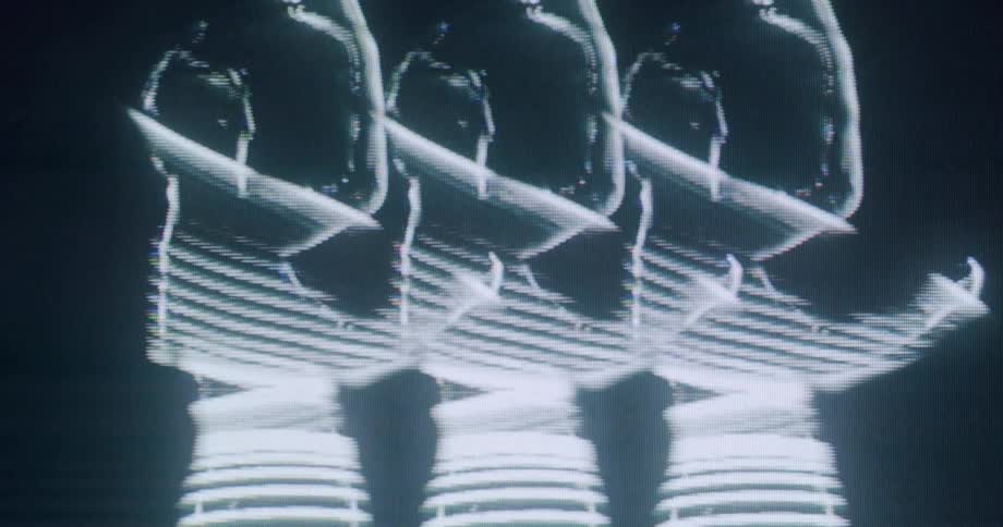 The outline of three women dance together in the hologram