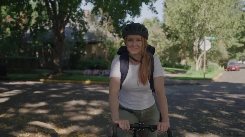 Woman with bicycle looks into camera