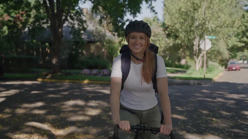 Woman smiling on her bicycle on the road