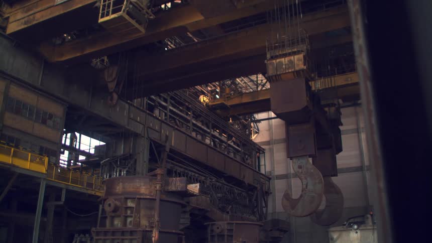 Factory interior with large metal structures and industrial cranes