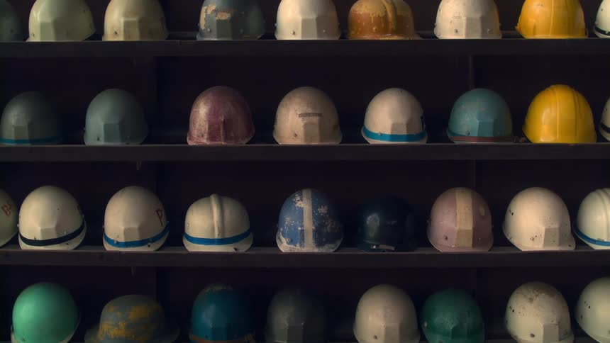 Old construction helmets neatly arranged on a shelf