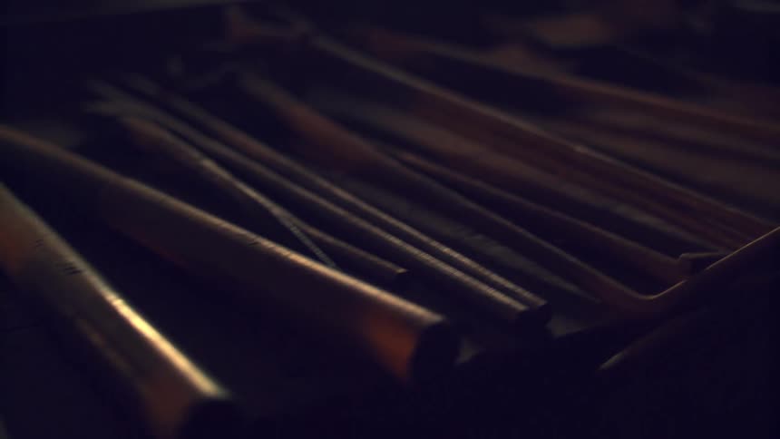 Set of metal tools laid out on a dark surface