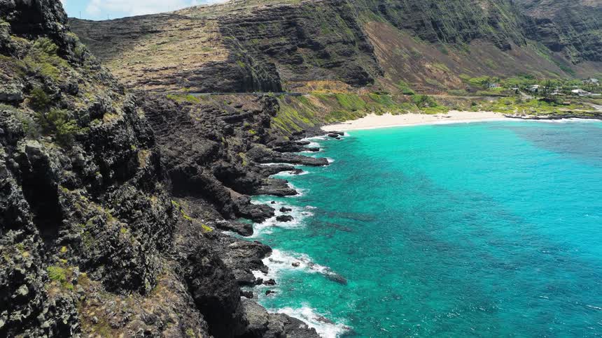 Aerial view of rocky cliffs and turquoise ocean along the coast