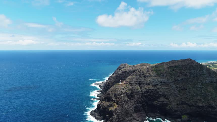 Aerial view of a rocky coastal cliff against the deep blue ocean