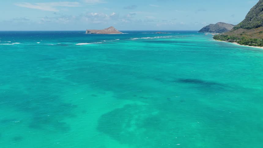 Aerial view of turquoise ocean with island and coastline