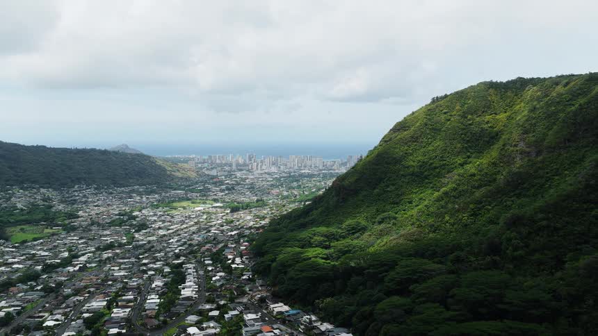 Coastal city seen from above surrounded by green mountains
