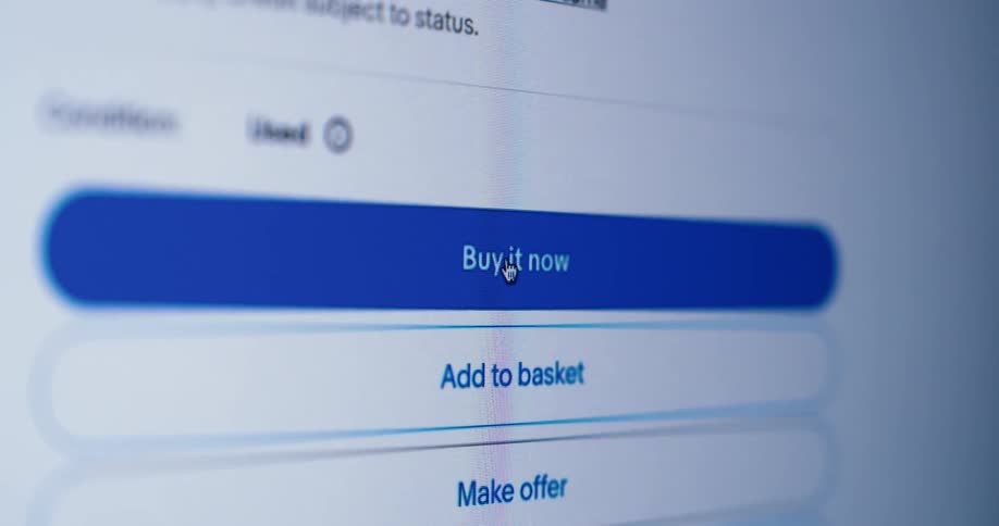 A mouse cursor clicking on the buy it now button of an auction site page
