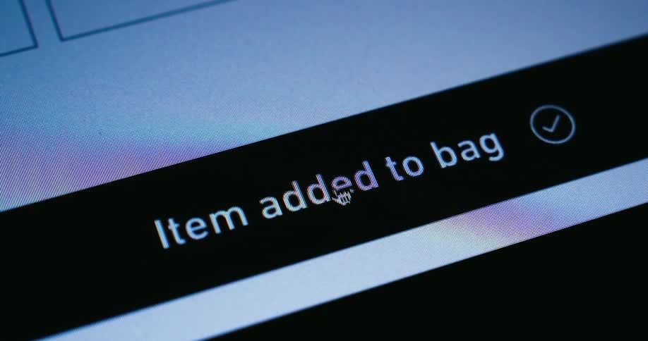 A cursor clicks an add to bag button on a yellow banner on a screen which then changes to a black banner confirming item added to bag with a checkmark