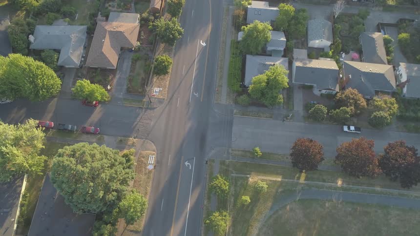Aerial view of a quiet suburban neighborhood intersection at sunset