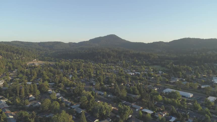 Aerial view of a town surrounded by treecovered hills