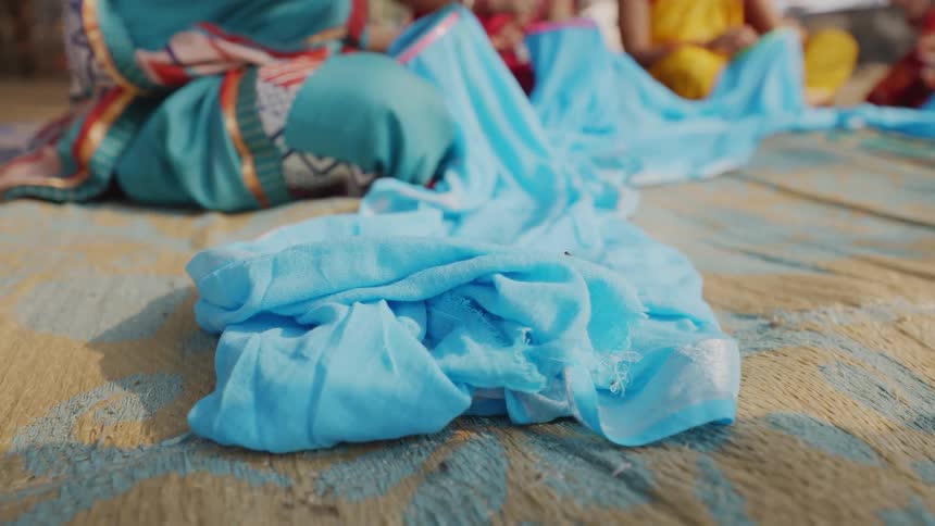 Blue fabrics spread on the ground during a group craft activity
