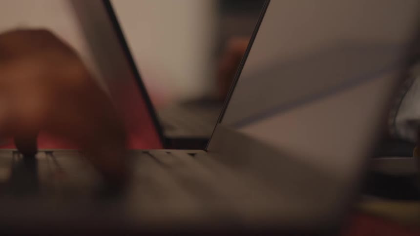 Closeup of hands typing on a laptop keyboard