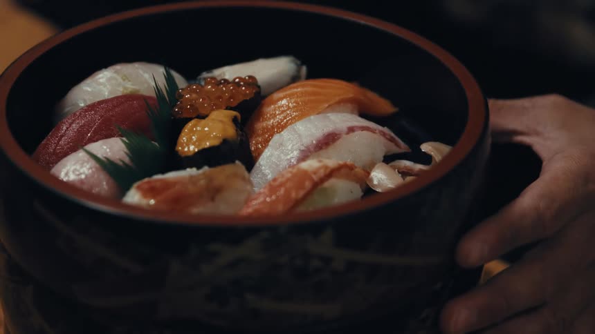 A person serves multiple sushi bowls