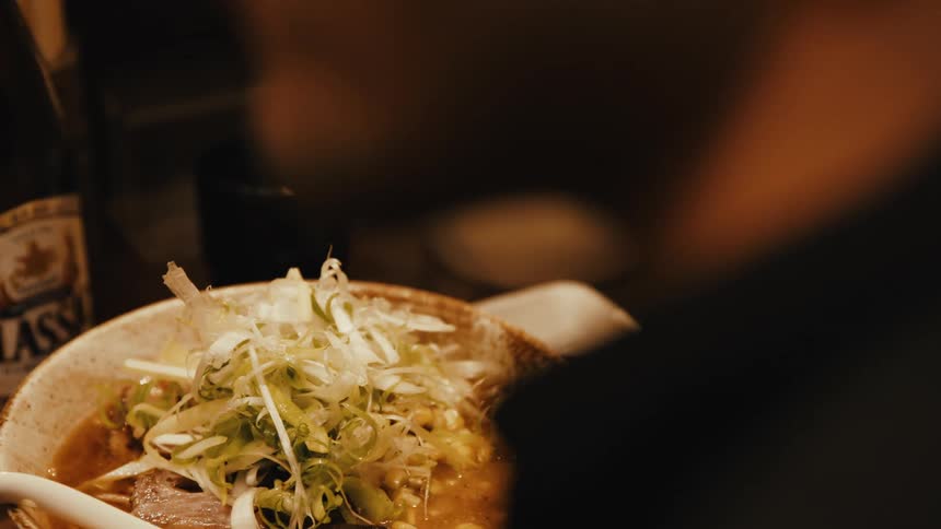 A bowl of food is sitting in front of a man as he talks
