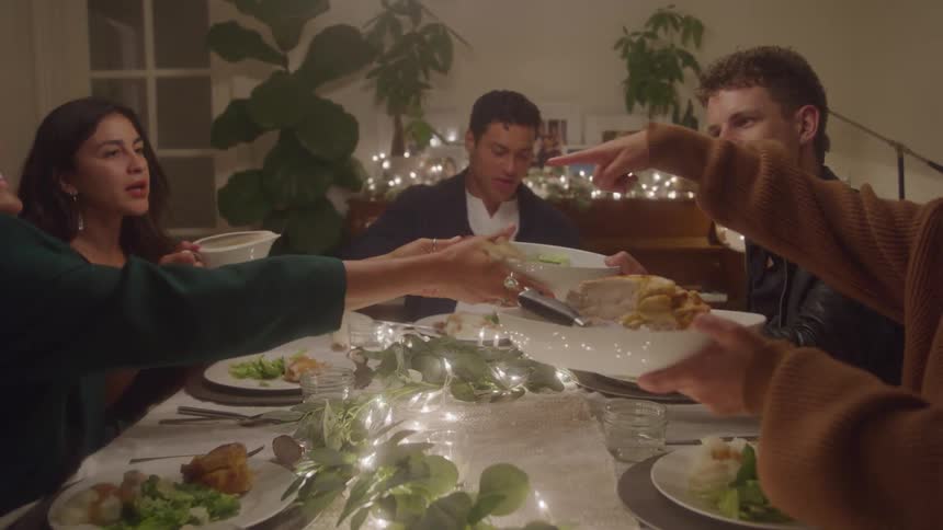 People talk and pass food at the dinner table