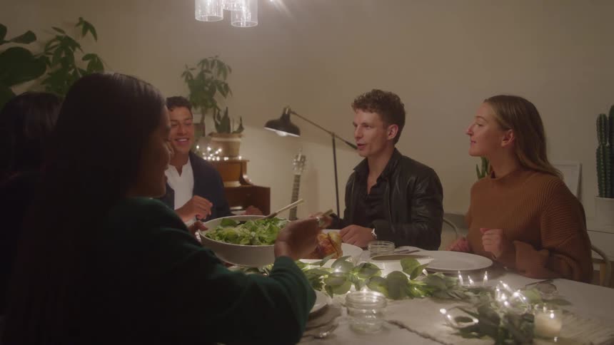 Four friends share a meal at a decorated dinner table