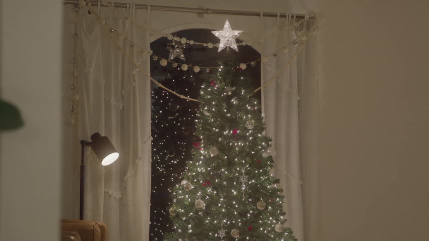 Decorated christmas tree glowing with lights indoors