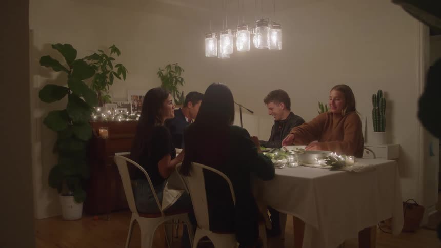 Group of people gathered around a table during a home dinner