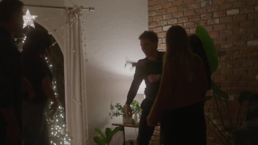 Friends gather and dance at a christmas celebration indoors