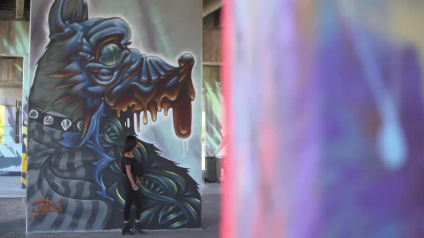 Woman walks past large wall artwork