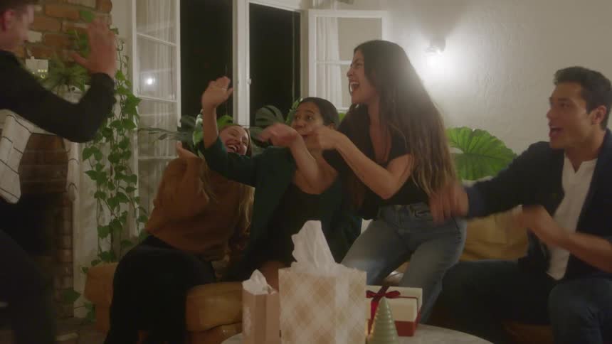 Group of friends enjoy themselves in a room decorated for celebration