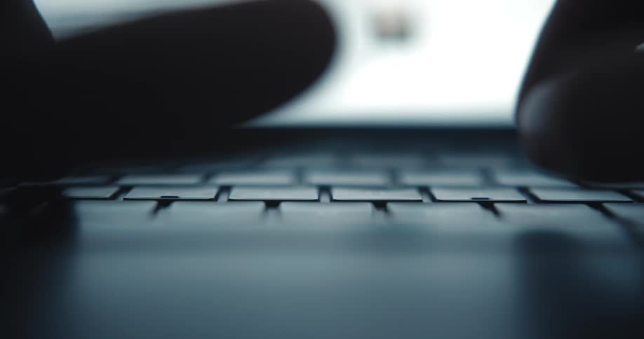 Close up of fingers typing on a laptop computer keyboard