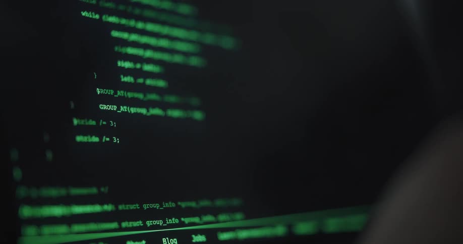 A view from the side shows a person using a computer writing a program in green text